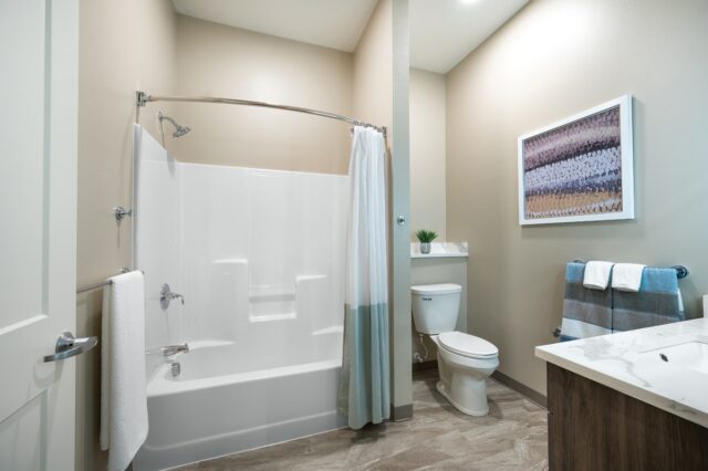 Apartment bathroom with tub and shower combination, vanity sink, toilet, and modern finishes at Villas at Stoney Point