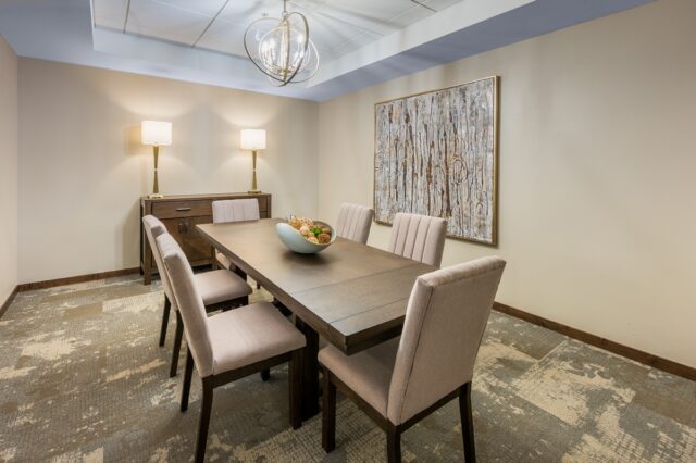 Private dining room with a long table, upholstered chairs, decorative lighting, and wall art in a comfortable setting at Villas at Stoney Point