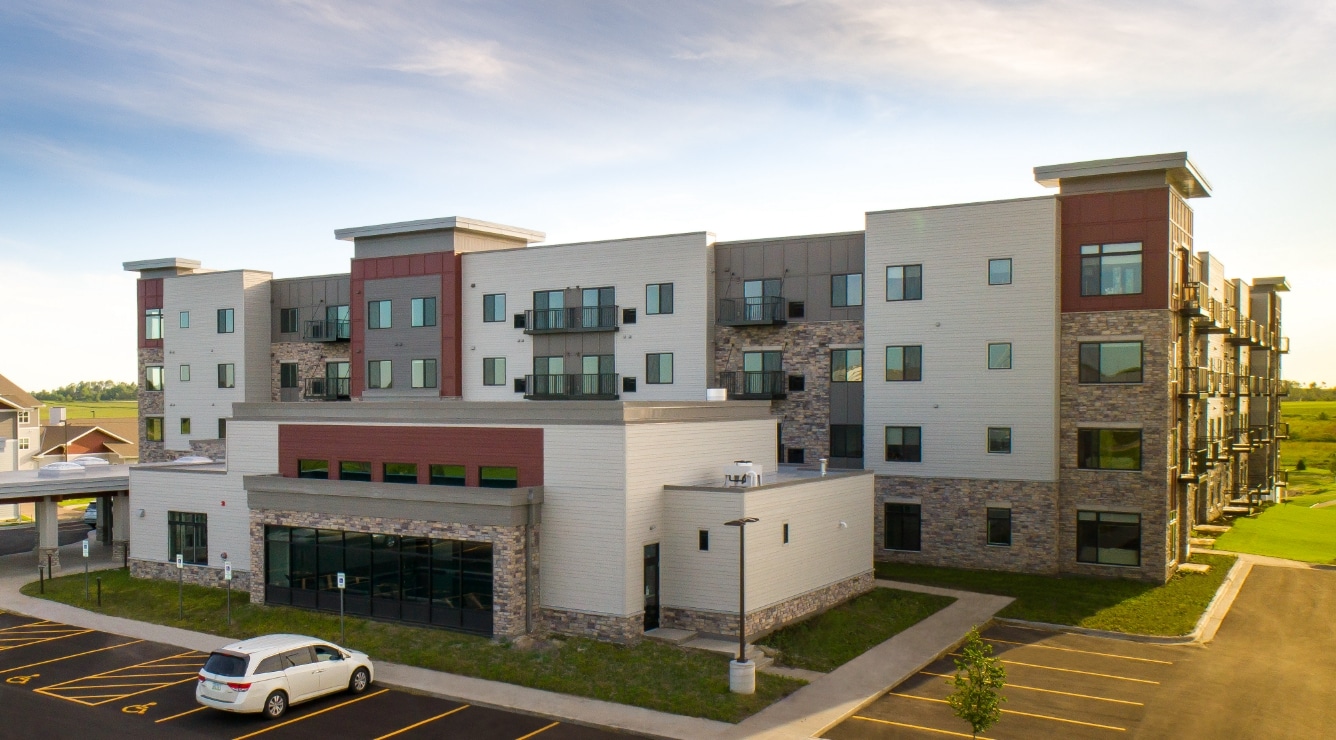 Exterior view of Villas at Stoney Point with multi-story residential building, balconies, and parking area in a landscaped setting