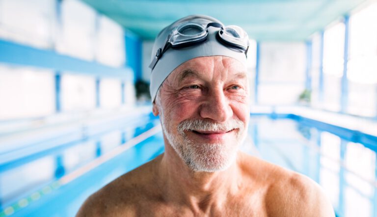 Adult wearing swim goggles in an indoor pool setting, representing active lifestyle and swimming amenities like Villas at Stoney Point
